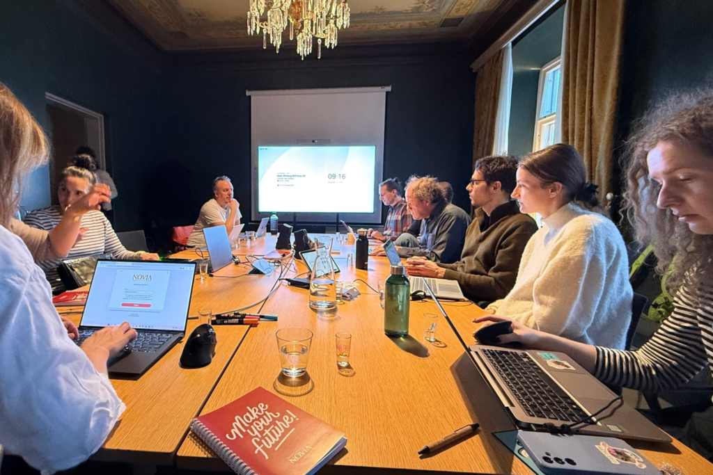 Lidé sedící u stolu a diskutující nad daným projektem.