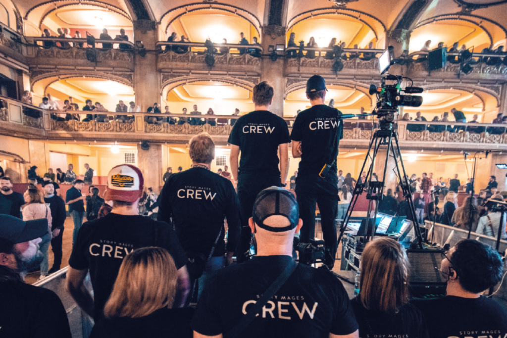 Lidé dívající se do sálu a stojící zády k foťáku