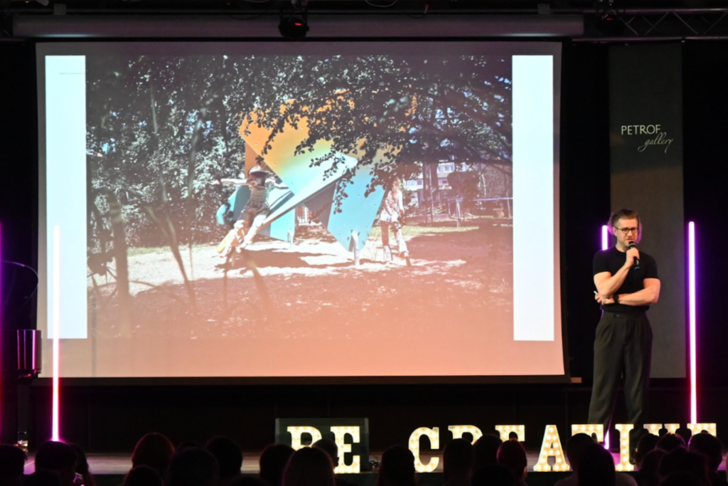 Muž stojící na podiu před prezentací.