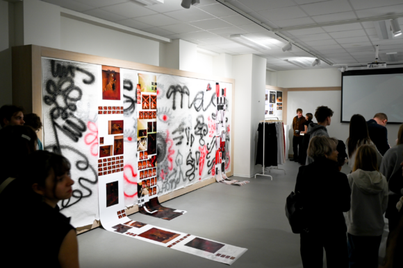 Vernisáž - návštěvníci stojící kolem moderního umění propojeného s fotkami.